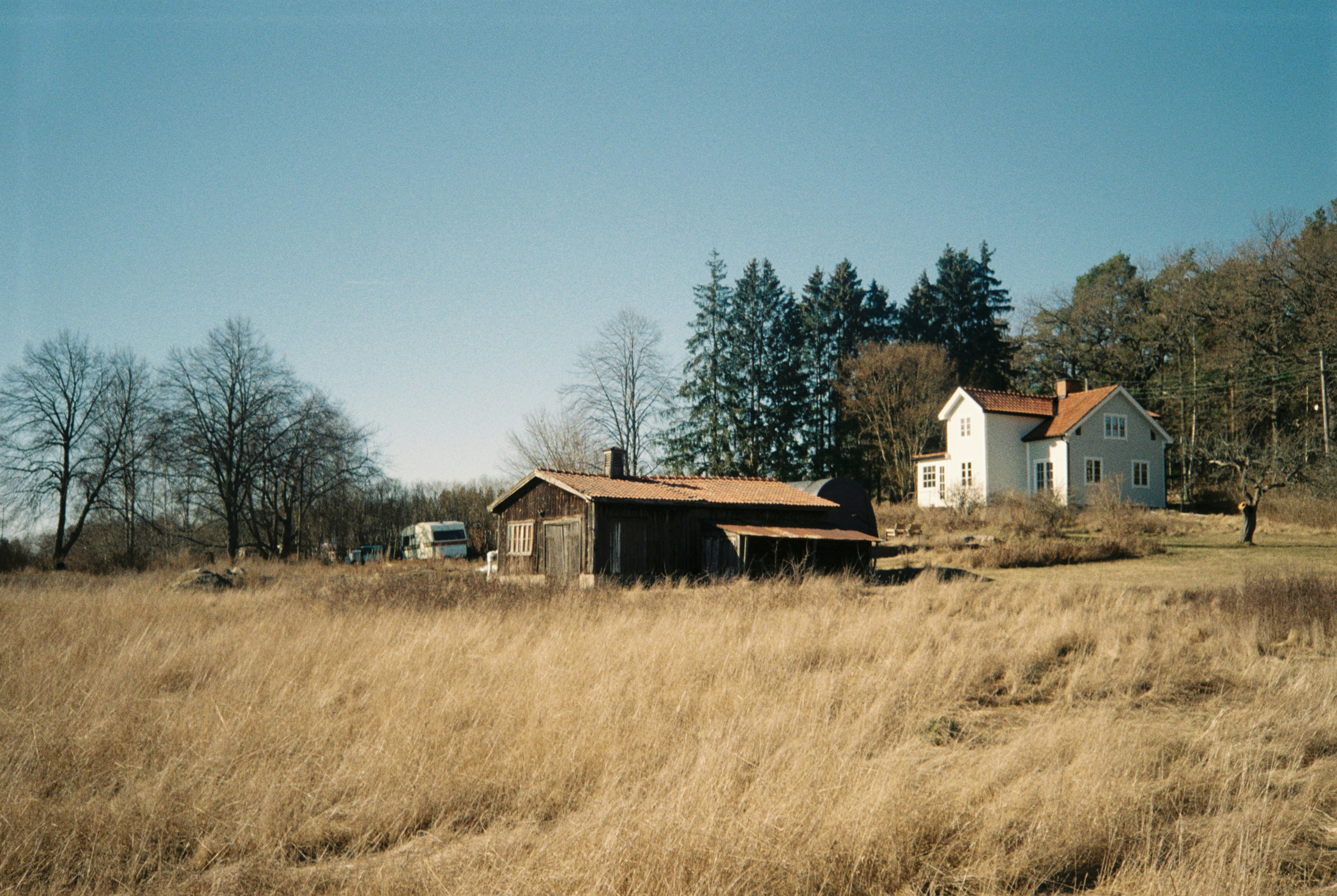 Rural landscape with a white house and barn.
