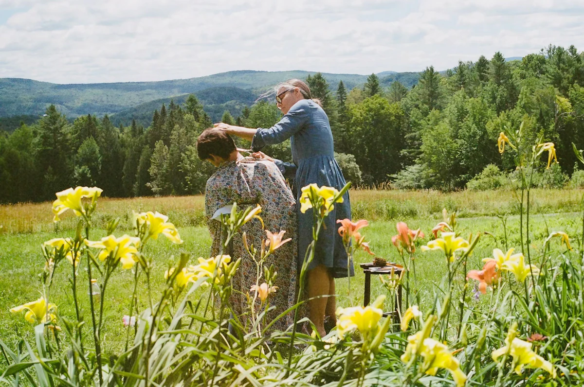 Two women in a meadow with flowers and trees