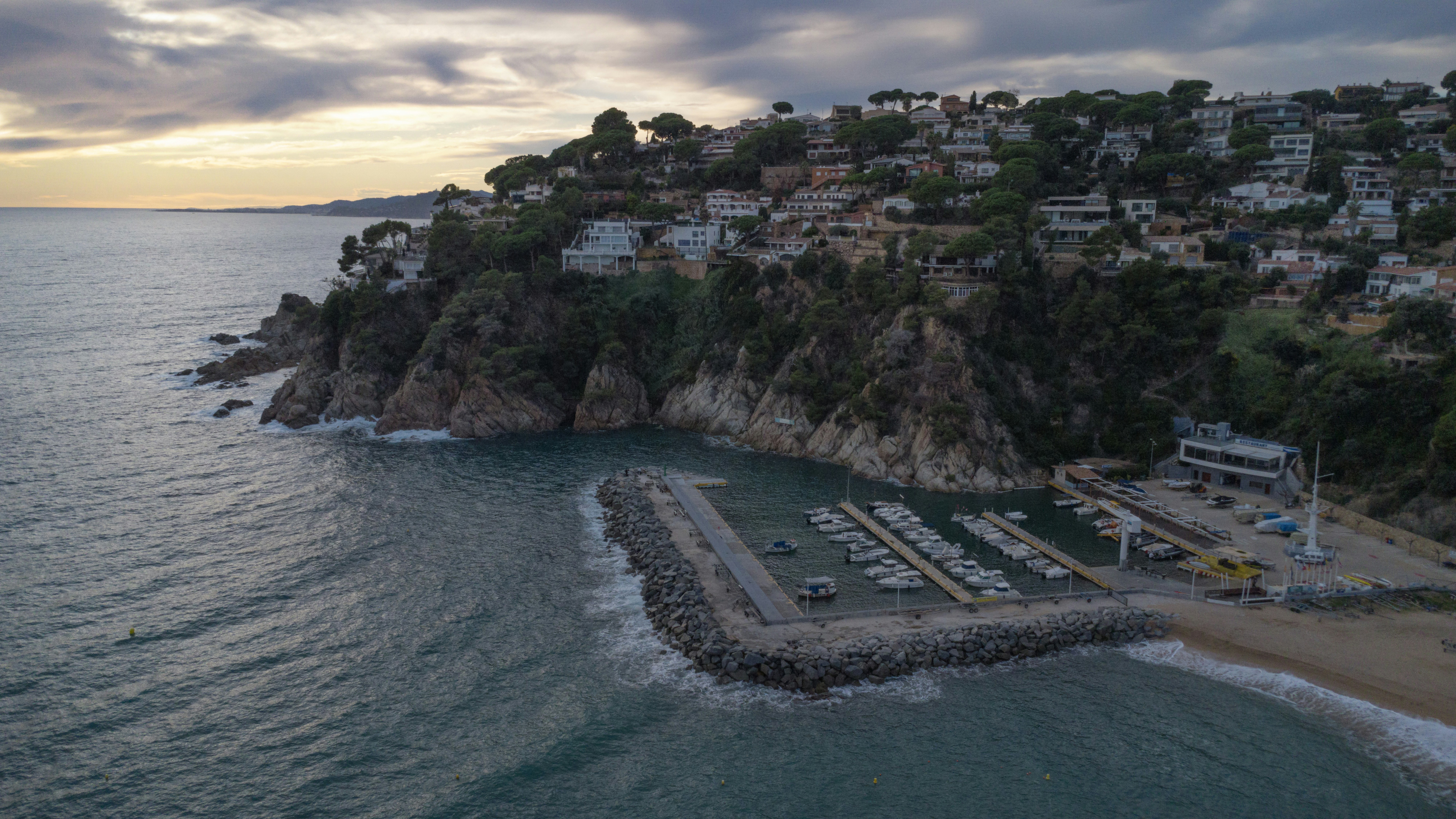 Coastal town with a small harbor and beach at sunset