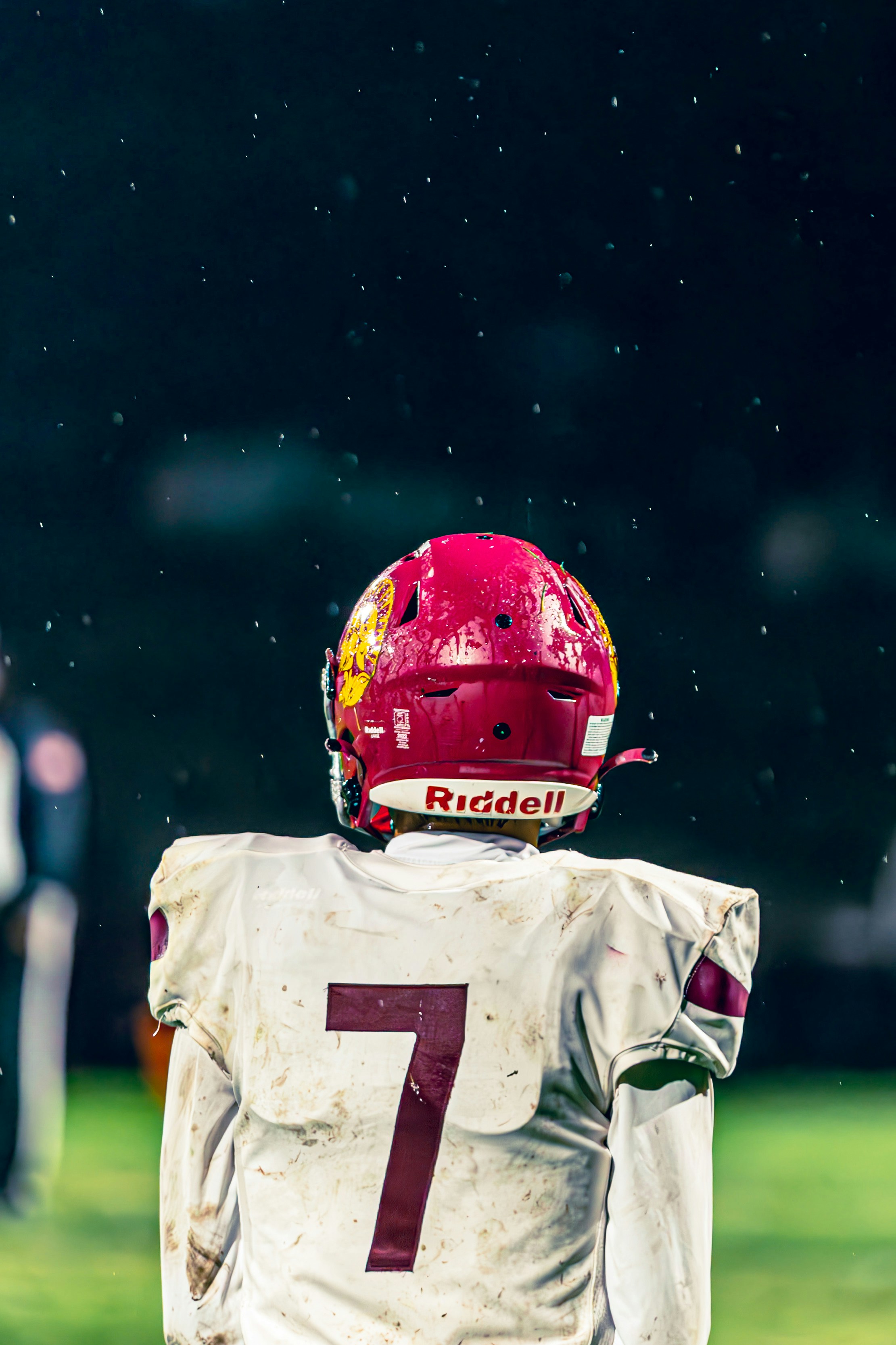 Football player in uniform with helmet on field.