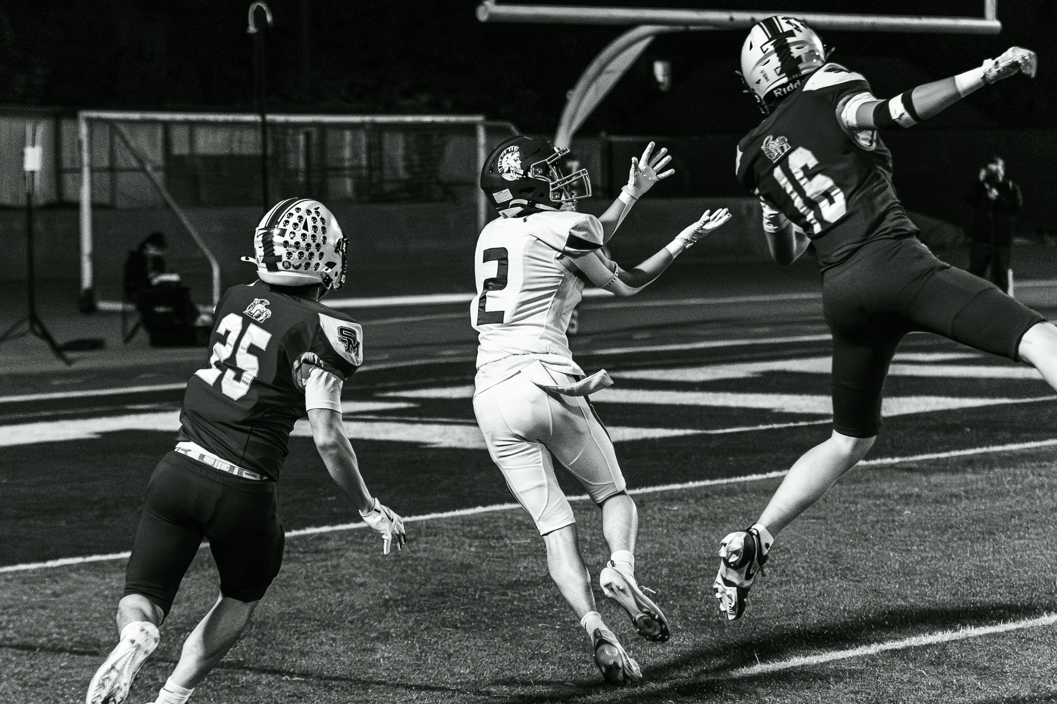 Analista revisando probabilidades de partido en una laptop junto al campo