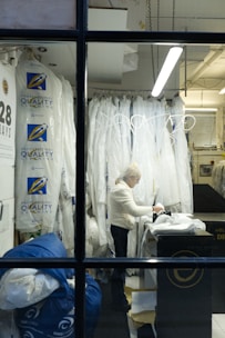 Woman working in a dry cleaning establishment with garments.