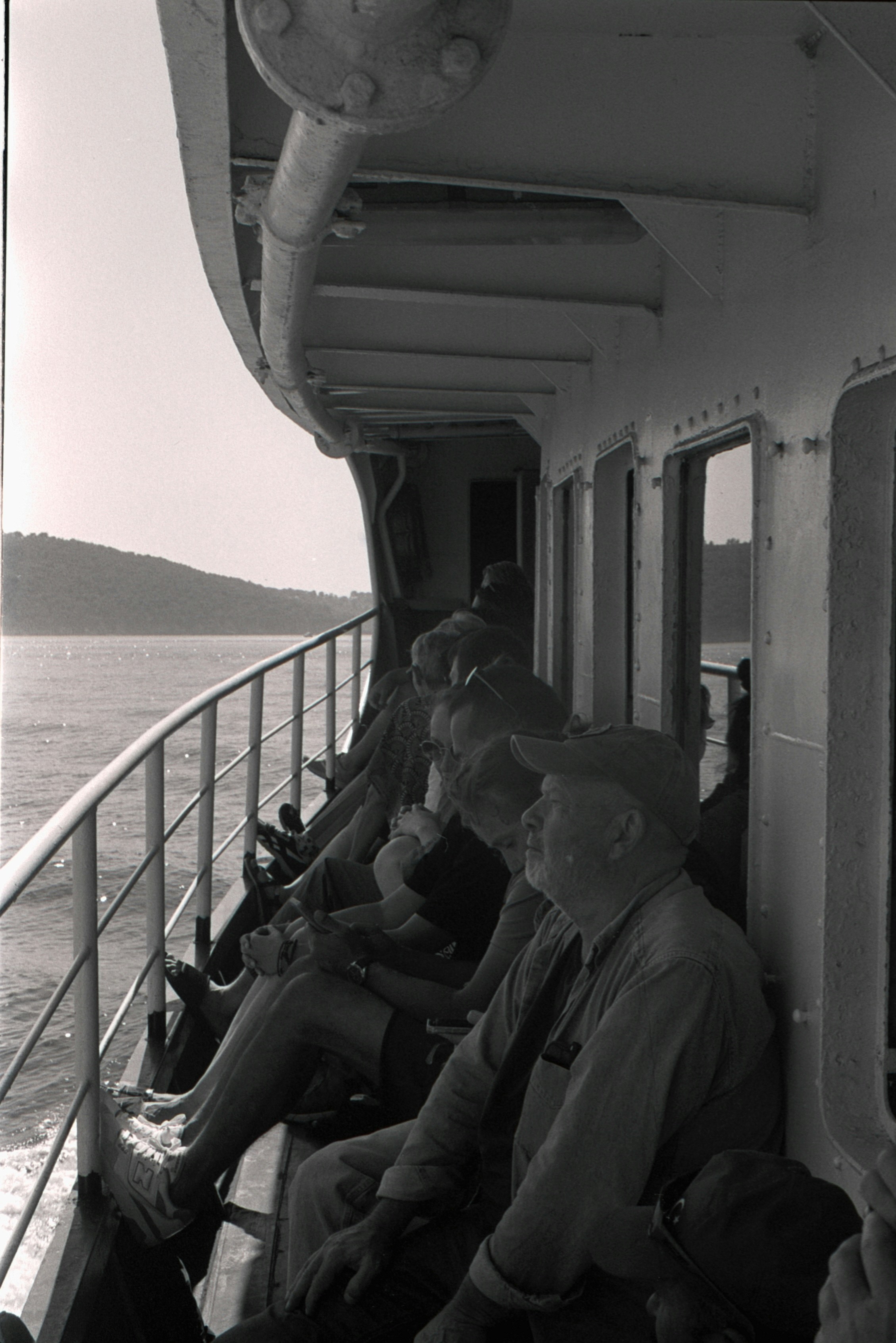 Gente sentada en un ferry con vistas al agua