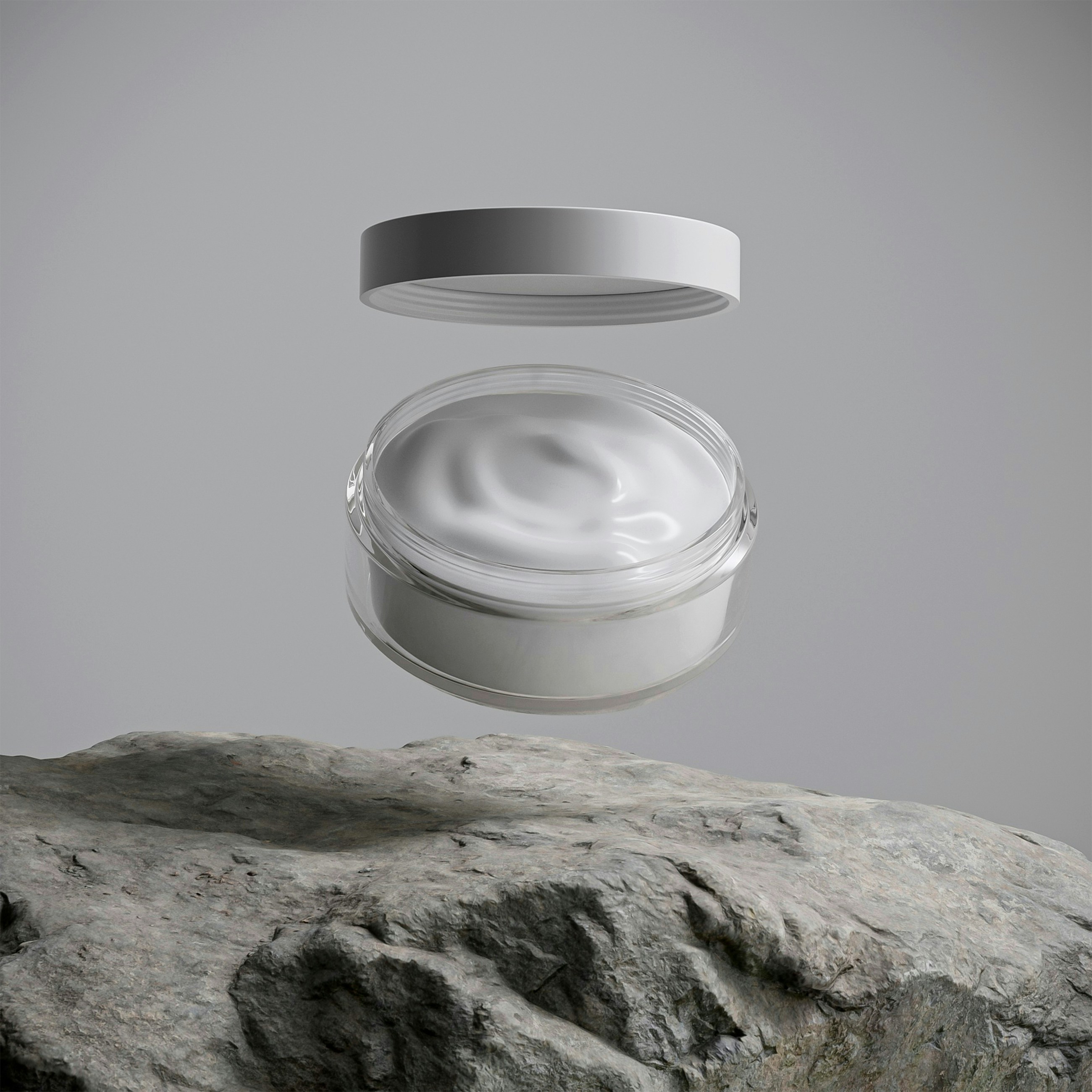 A jar of white cream floats above a rock.