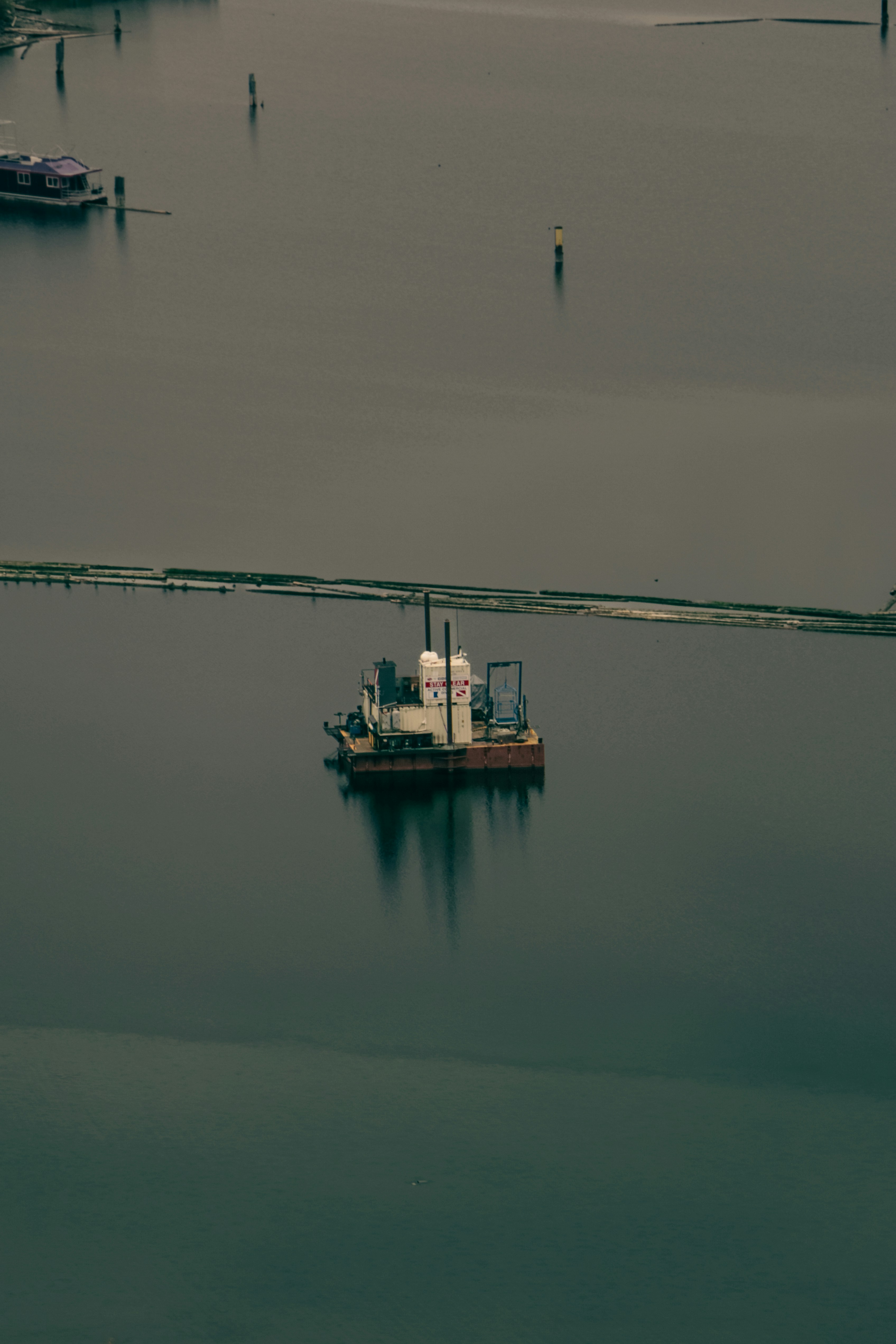 A barge floats on calm, dark water.