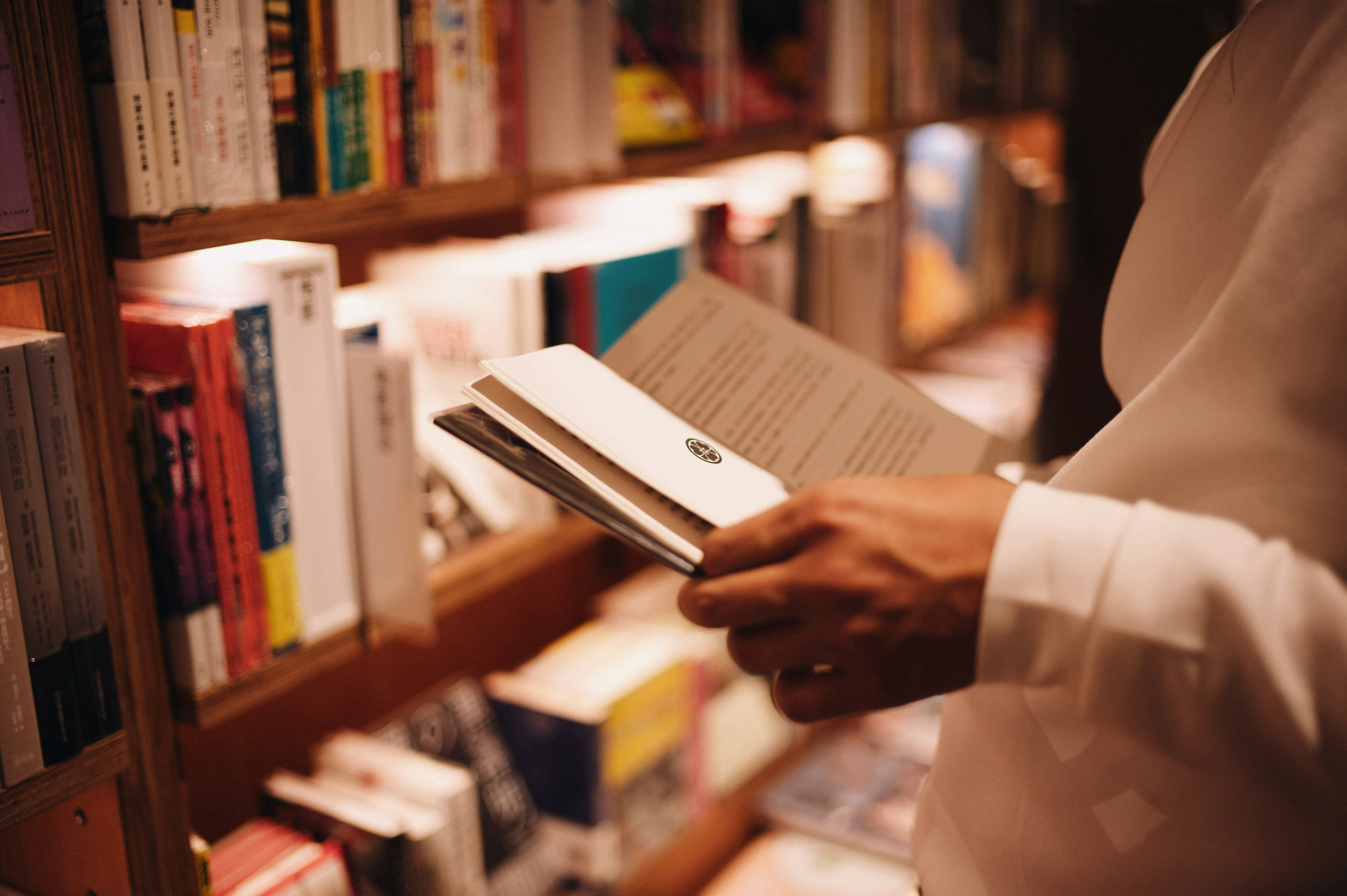 Person browsing books on a shelf