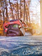 Orange kubota skid steer loader on gravel road