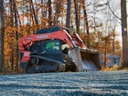 Orange kubota skid steer loader on gravel
