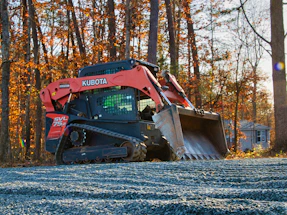 Orange kubota skid steer loader on gravel