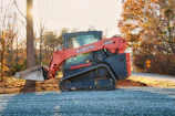 Orange kubota skid steer loader on gravel