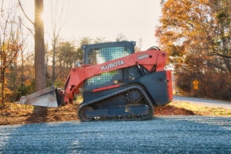 Orange kubota skid steer loader on gravel