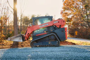 Orange kubota skid steer loader on gravel