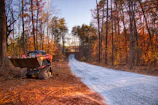 Skid steer loader on a gravel road in autumn forest