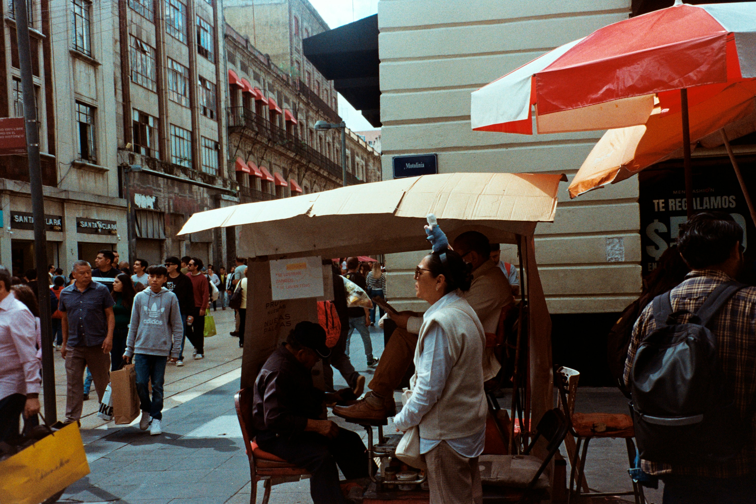 People on a busy city street with market stalls