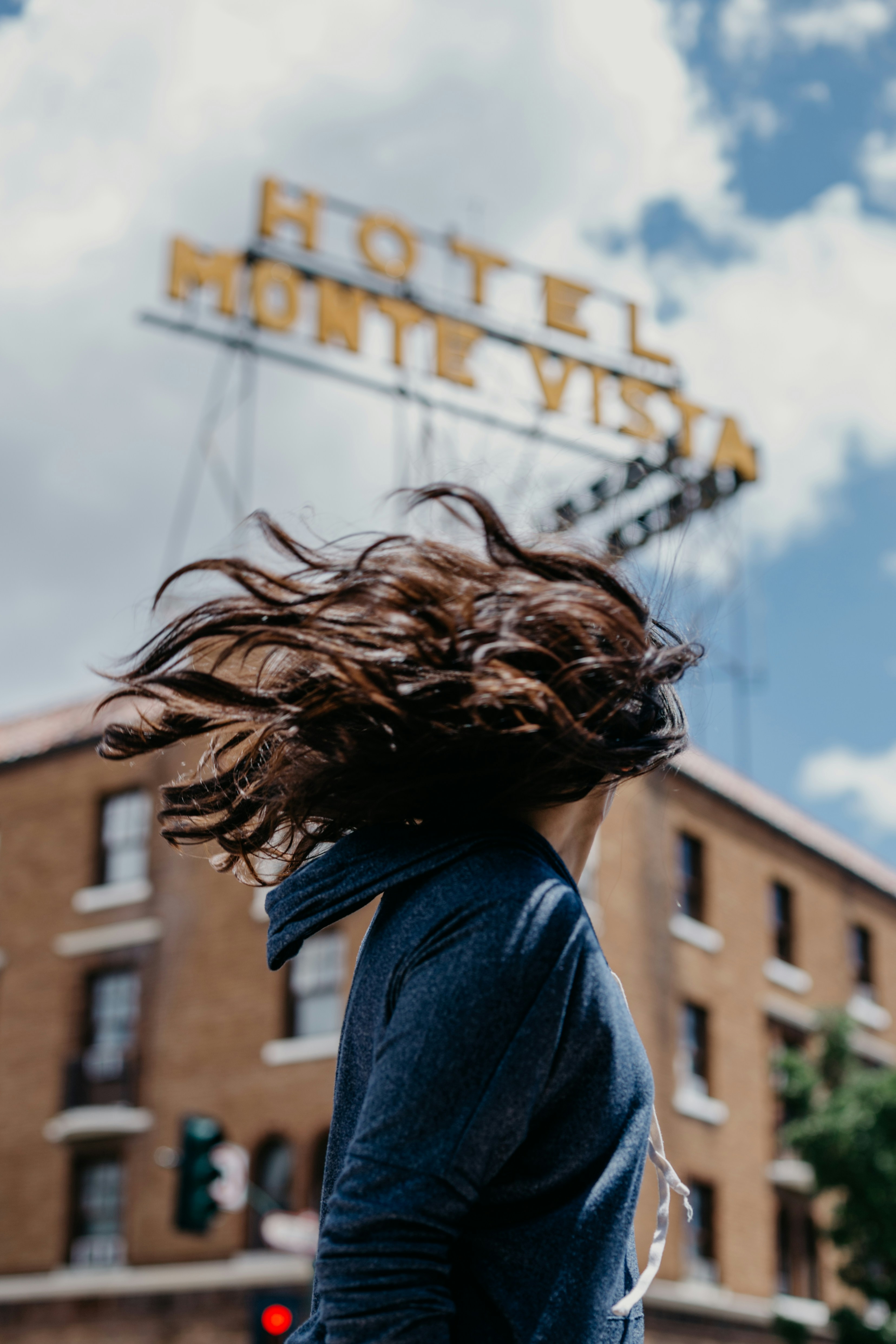 Mulher com cabelo bagunçado em frente ao Hotel Monte Vista.