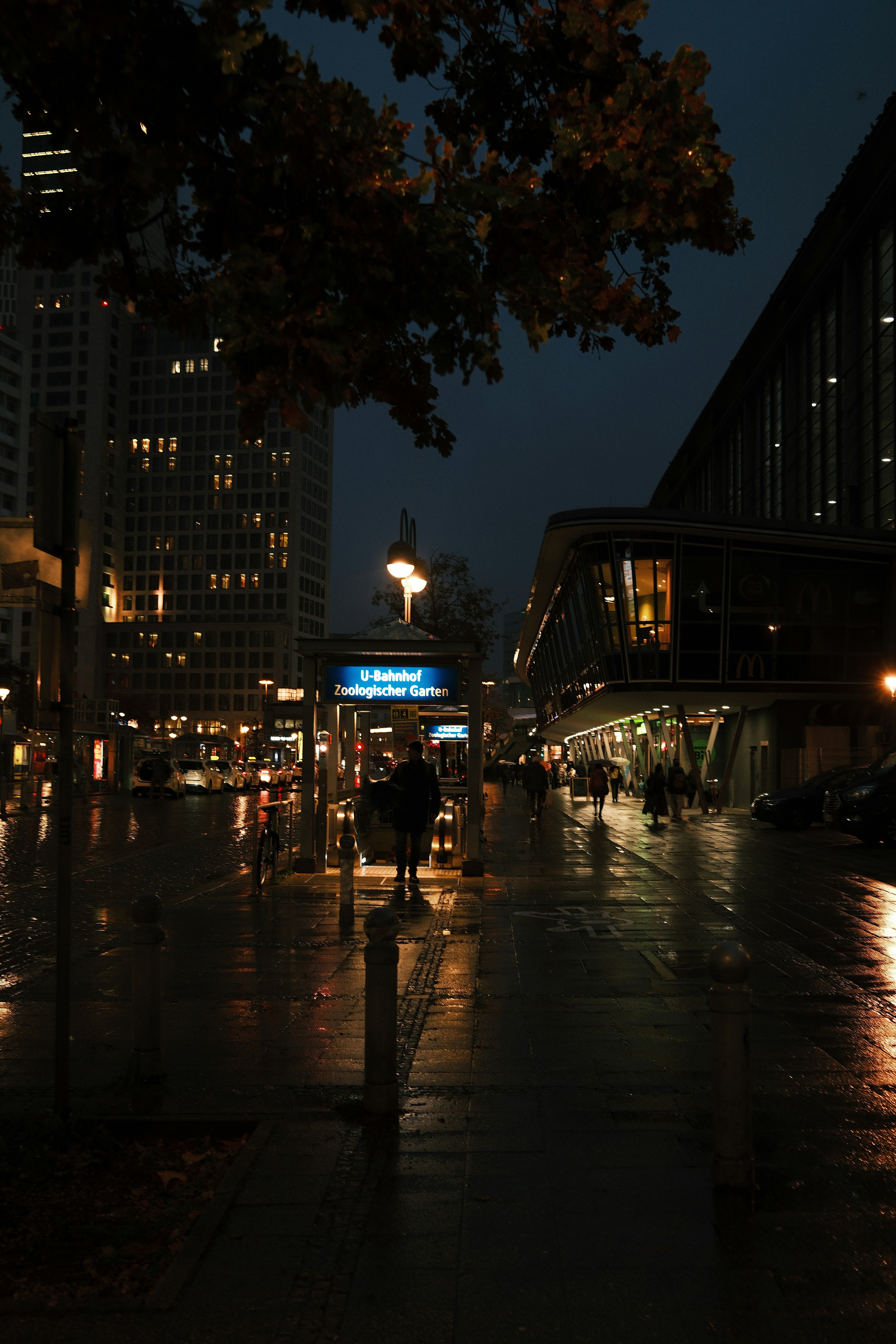 City street at night with wet pavement and lights.