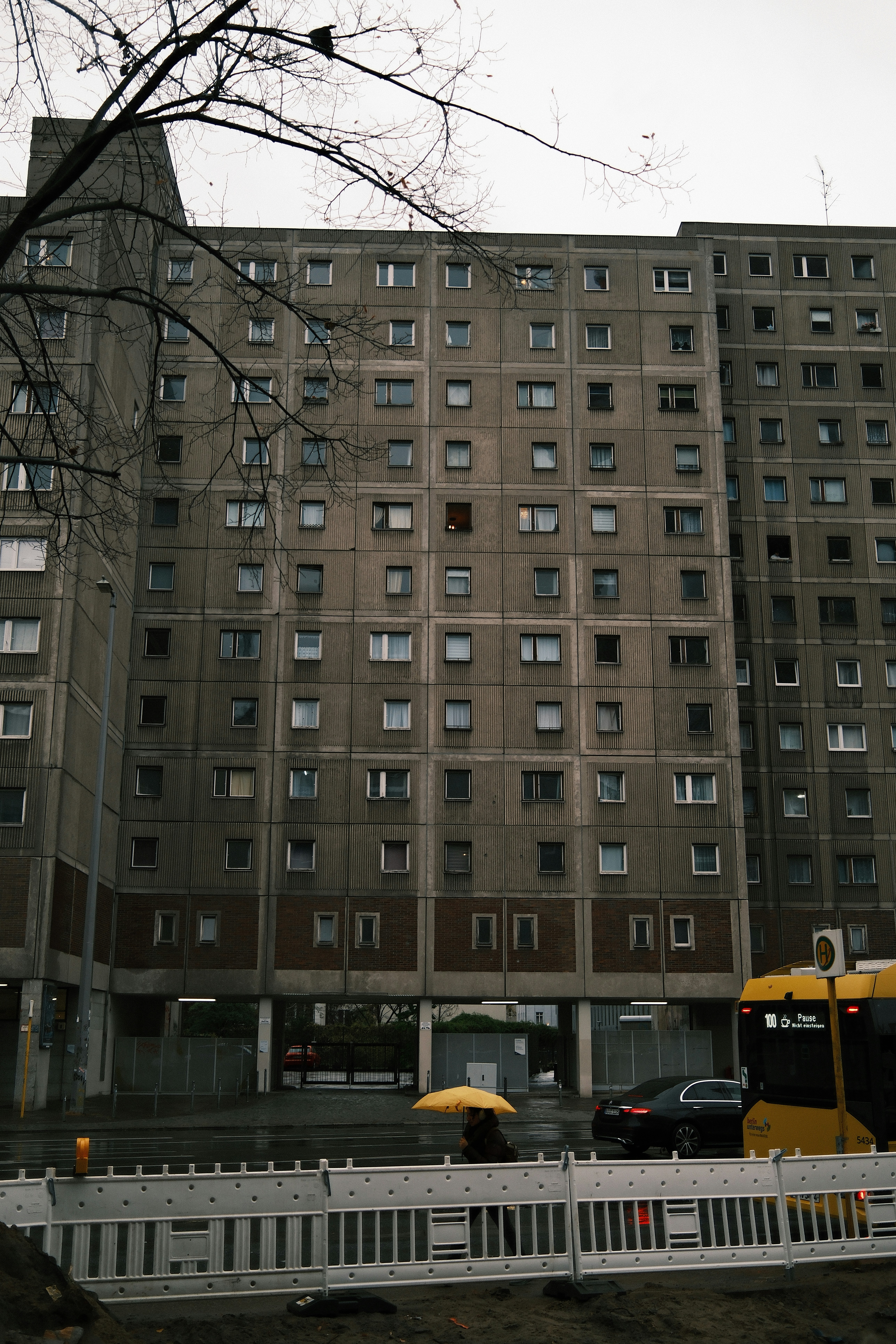 Tall concrete apartment building with many windows.