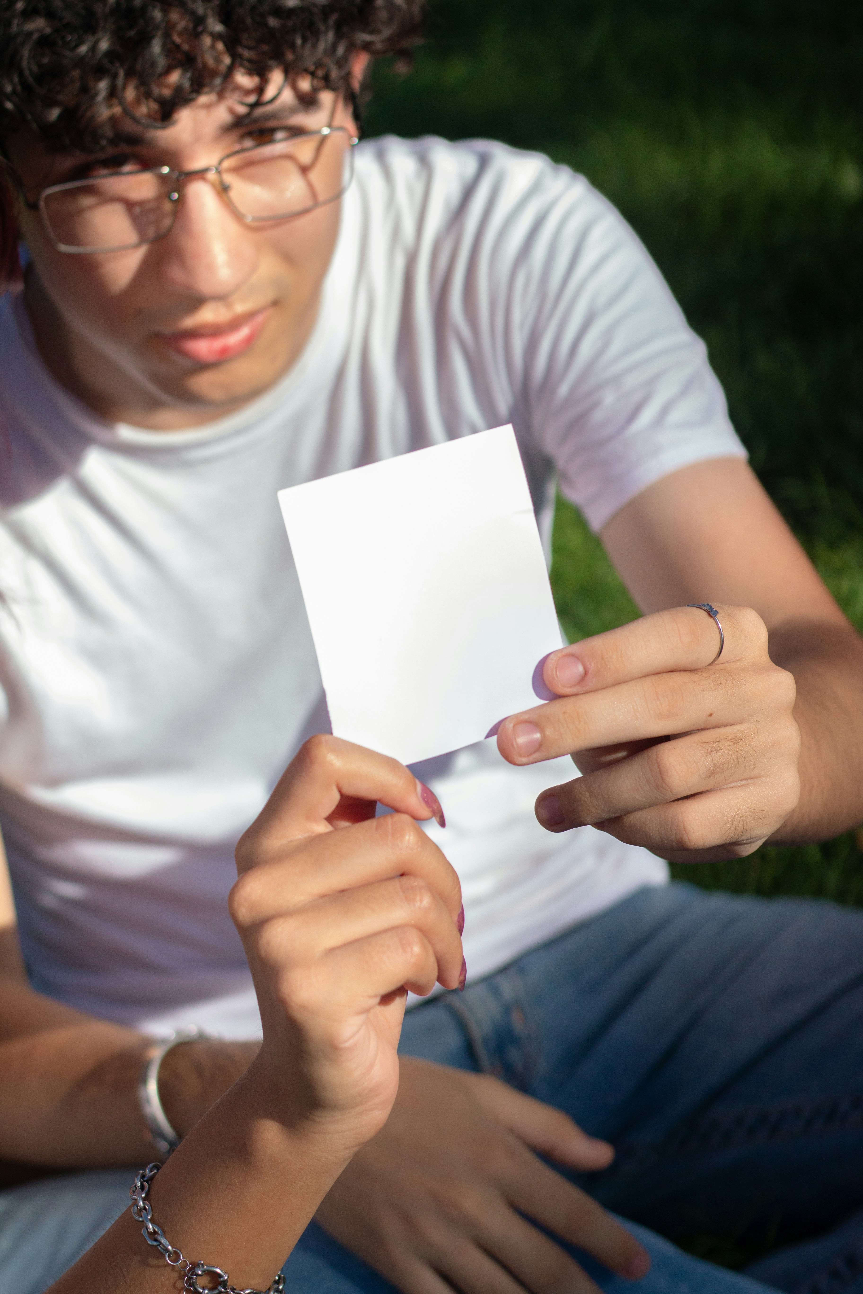 Young man holds up a blank white card