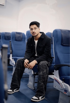 Young man sitting on airplane seats wearing jacket