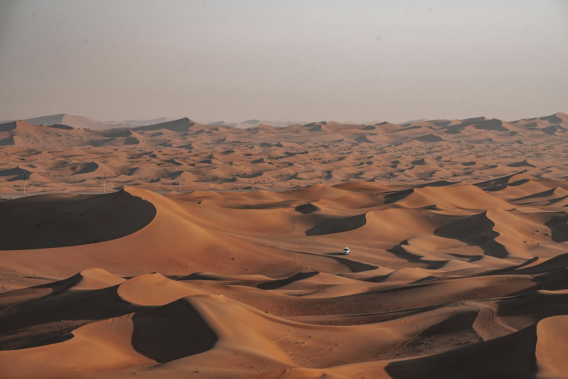 Vast desert sand dunes under a hazy sky