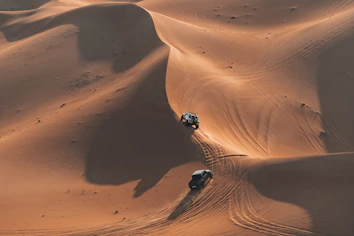 Two atvs driving on sand dunes