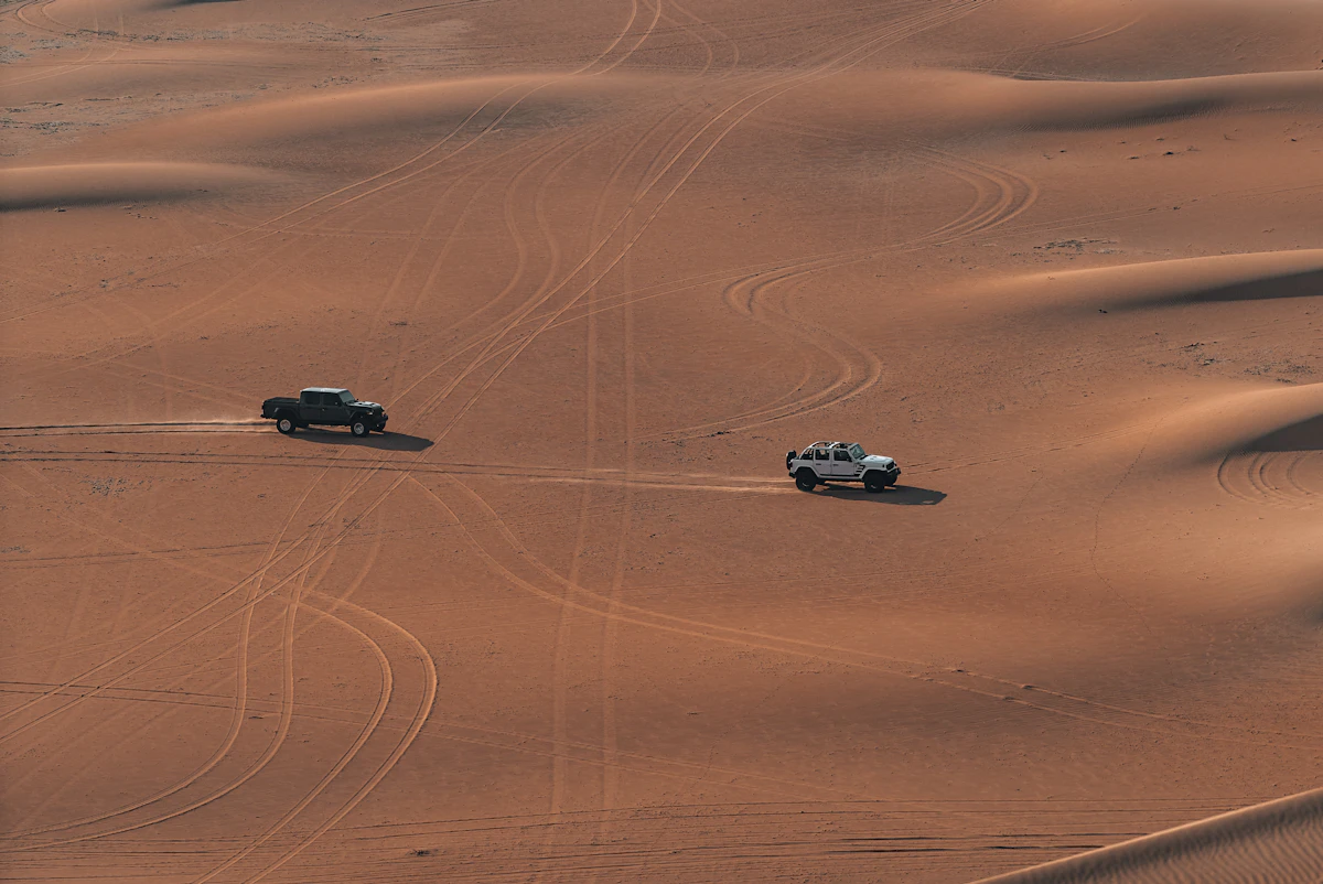 Off-road vehicle driving over Dubai desert sand dunes