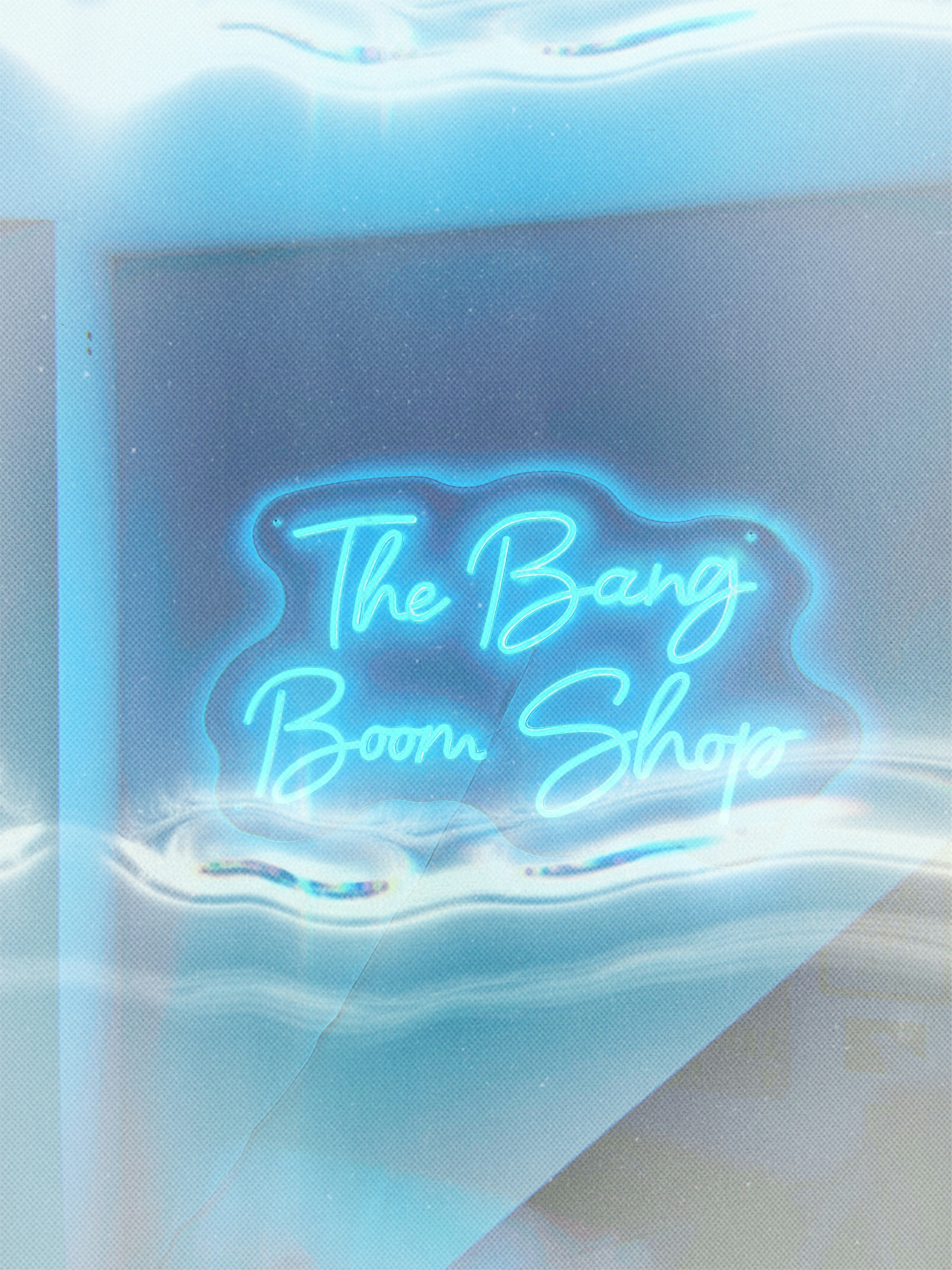 Enseigne au néon bleue épelant « the bang boom shop »