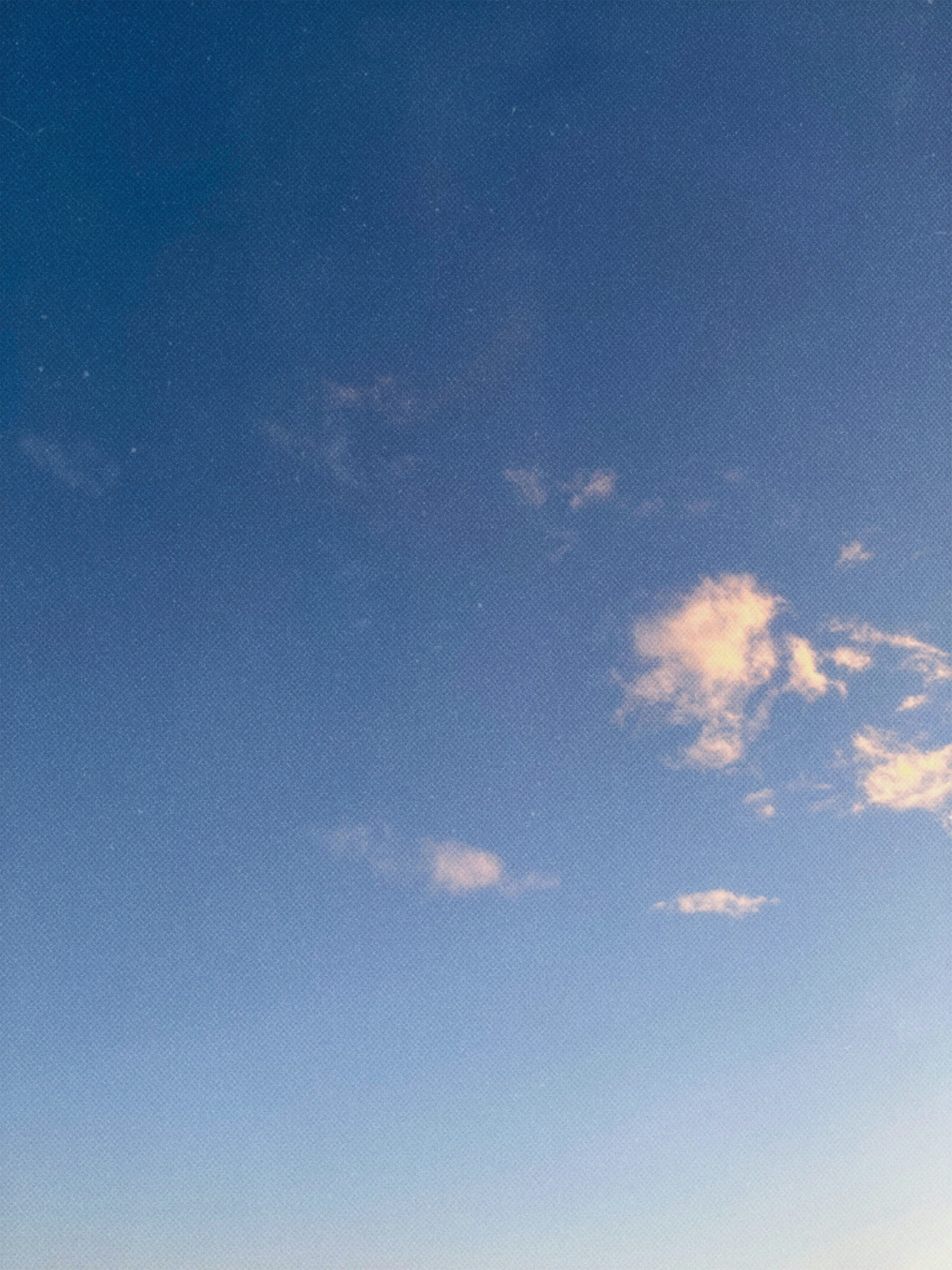 Clear blue sky with scattered light clouds.