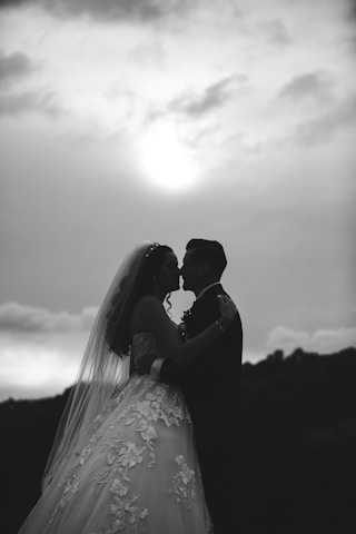 Bride and groom silhouetted against the sun