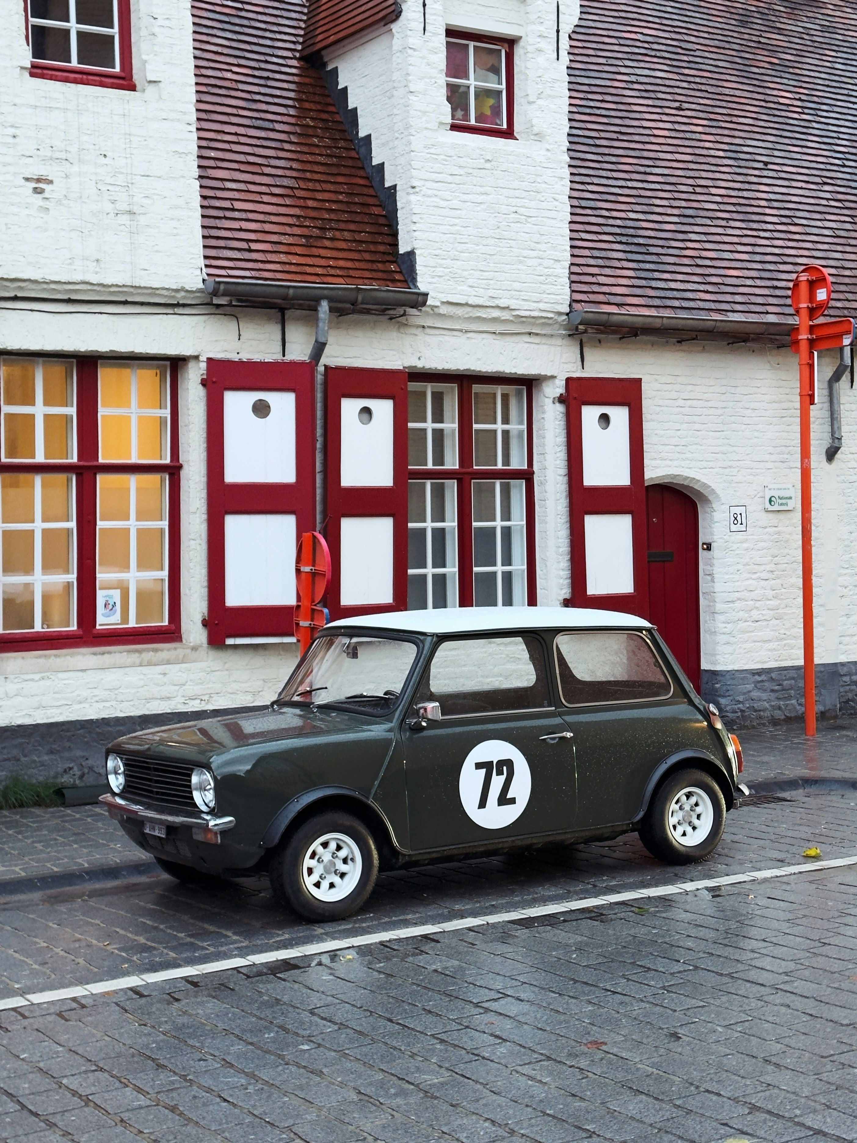 Un mini cooper vintage verde oscuro con el número 72.