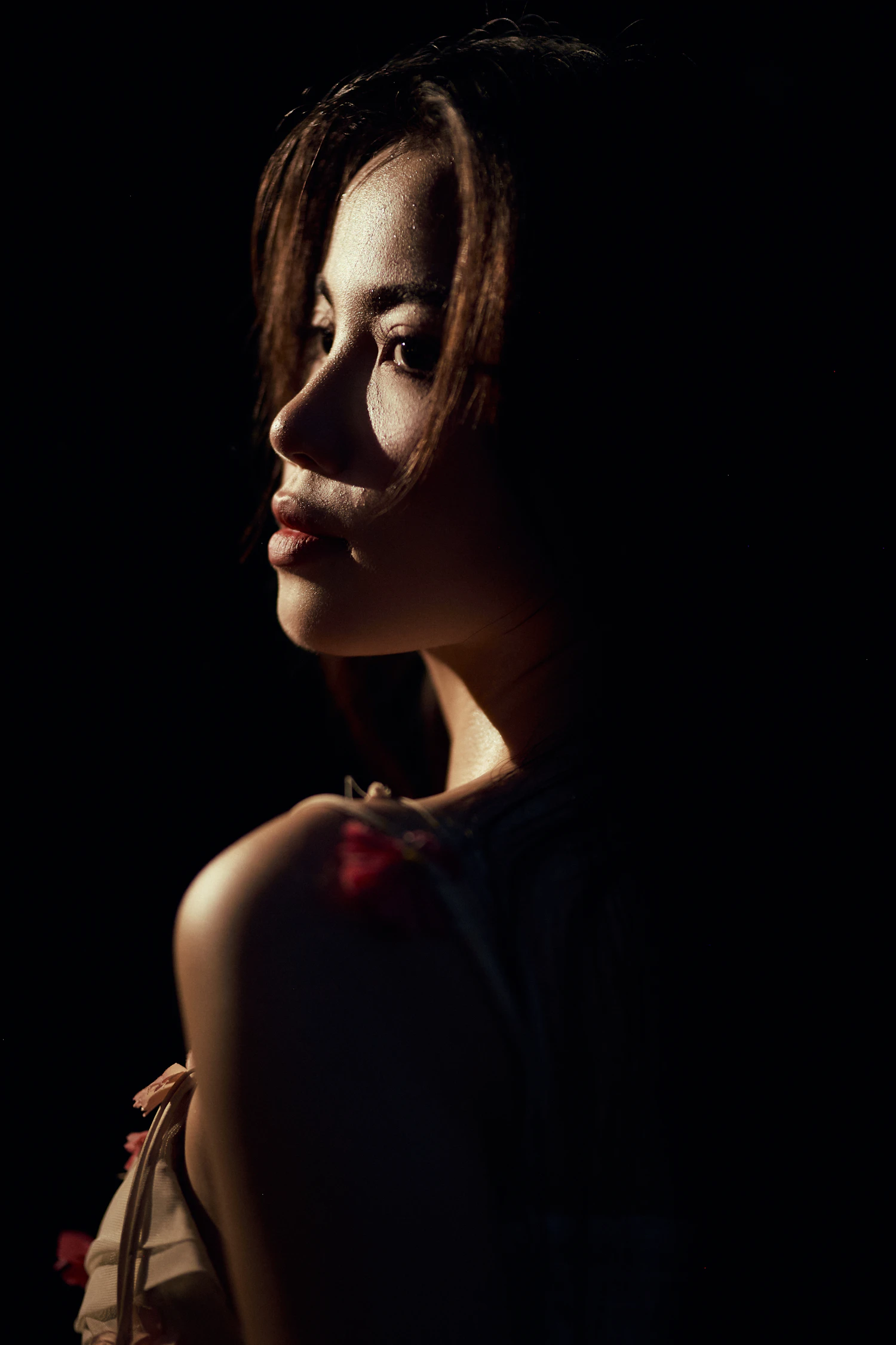 Moody editorial portrait shaped by warm side light
