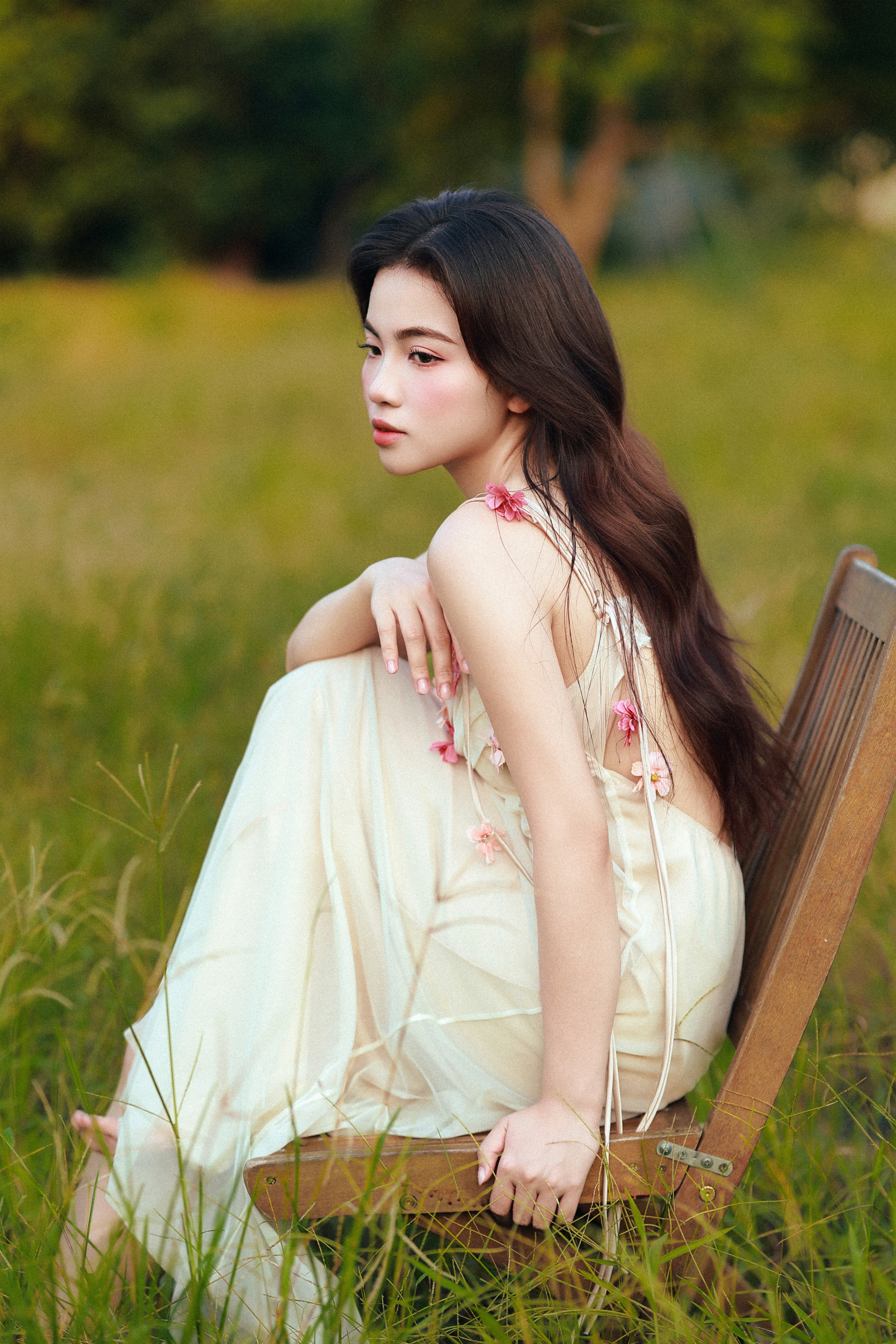 Young woman in a floral dress during golden hour.