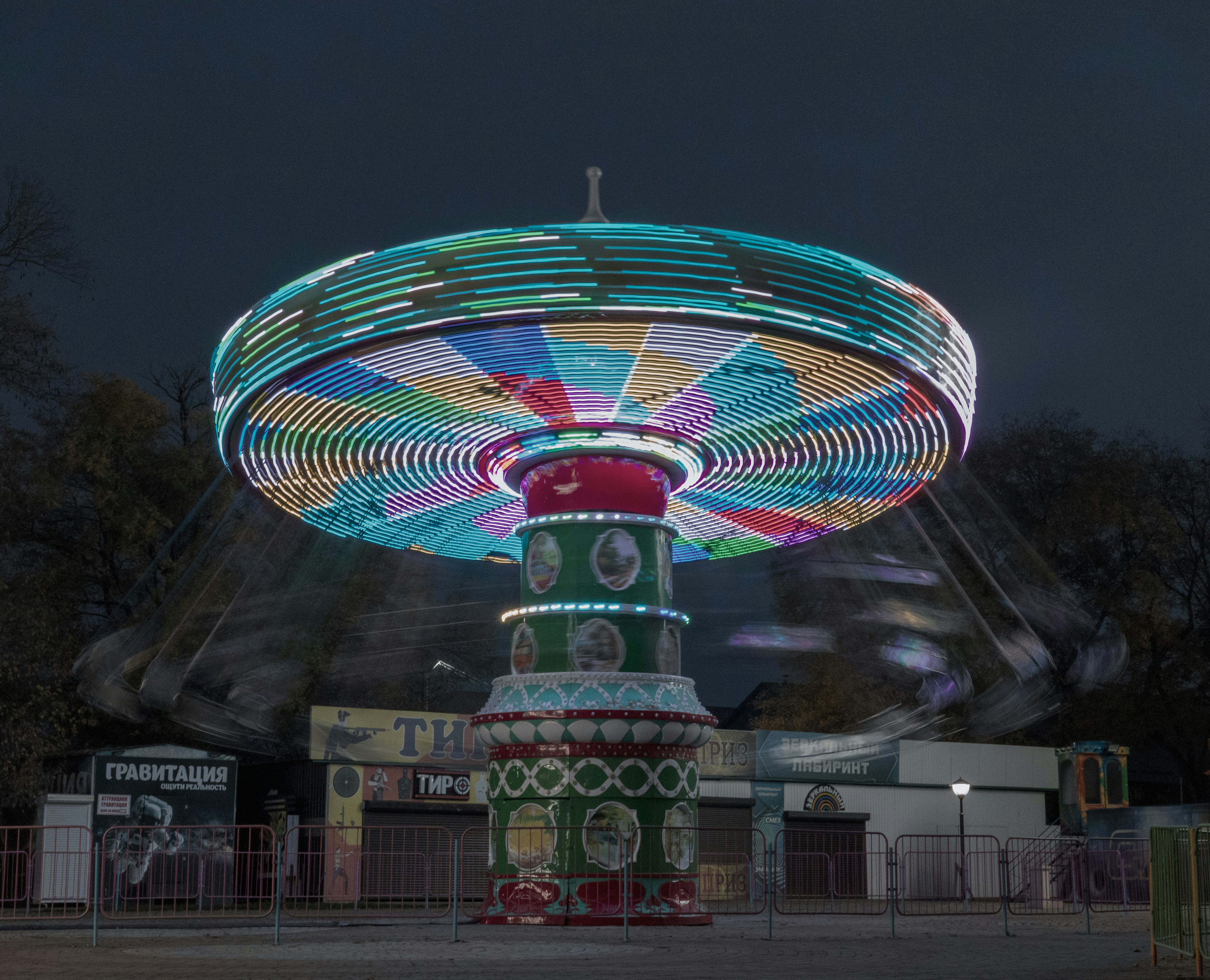 Colorful amusement park ride spinning at night