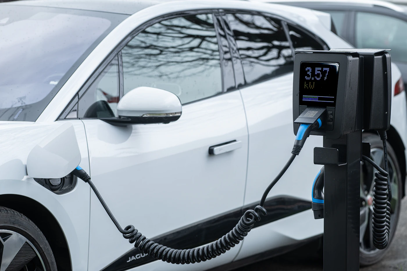 A white electric car charging at a public station