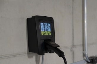 Electric car charger on a concrete wall