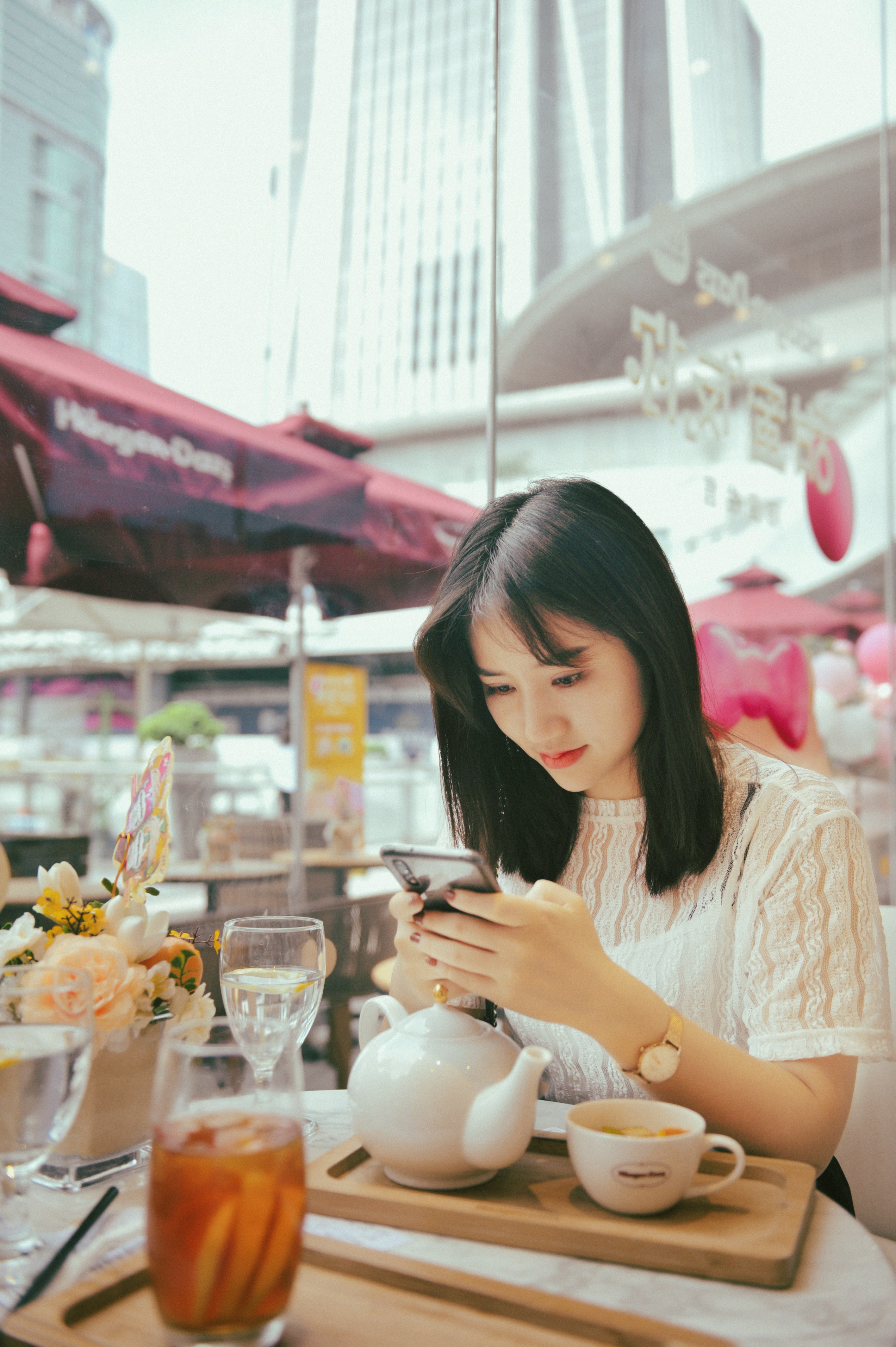 Woman looking at her phone at a cafe table