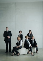 Group of business people in formal attire posing indoors