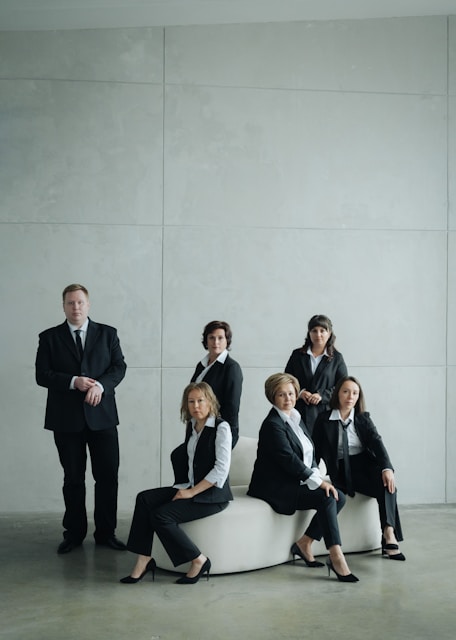 Group of business people in formal attire posing indoors