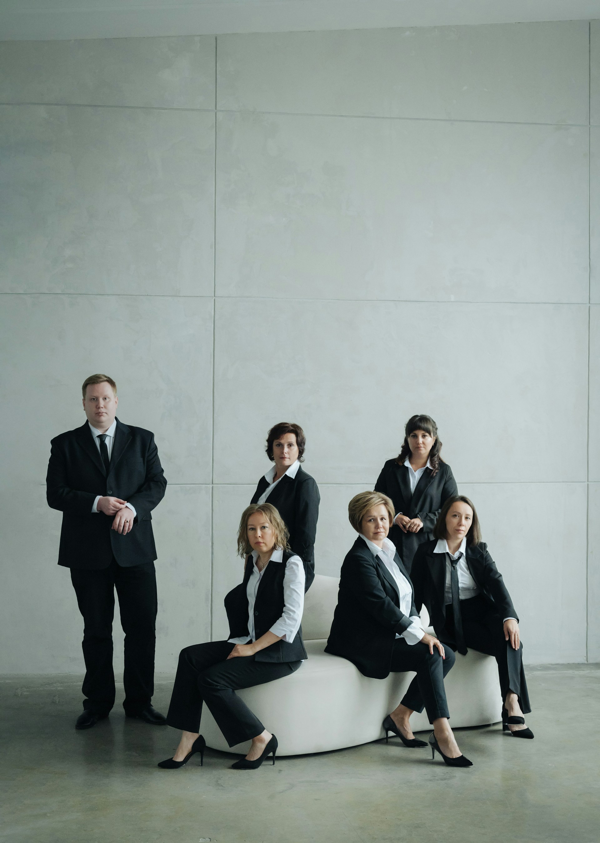 Group of business people in formal attire posing indoors