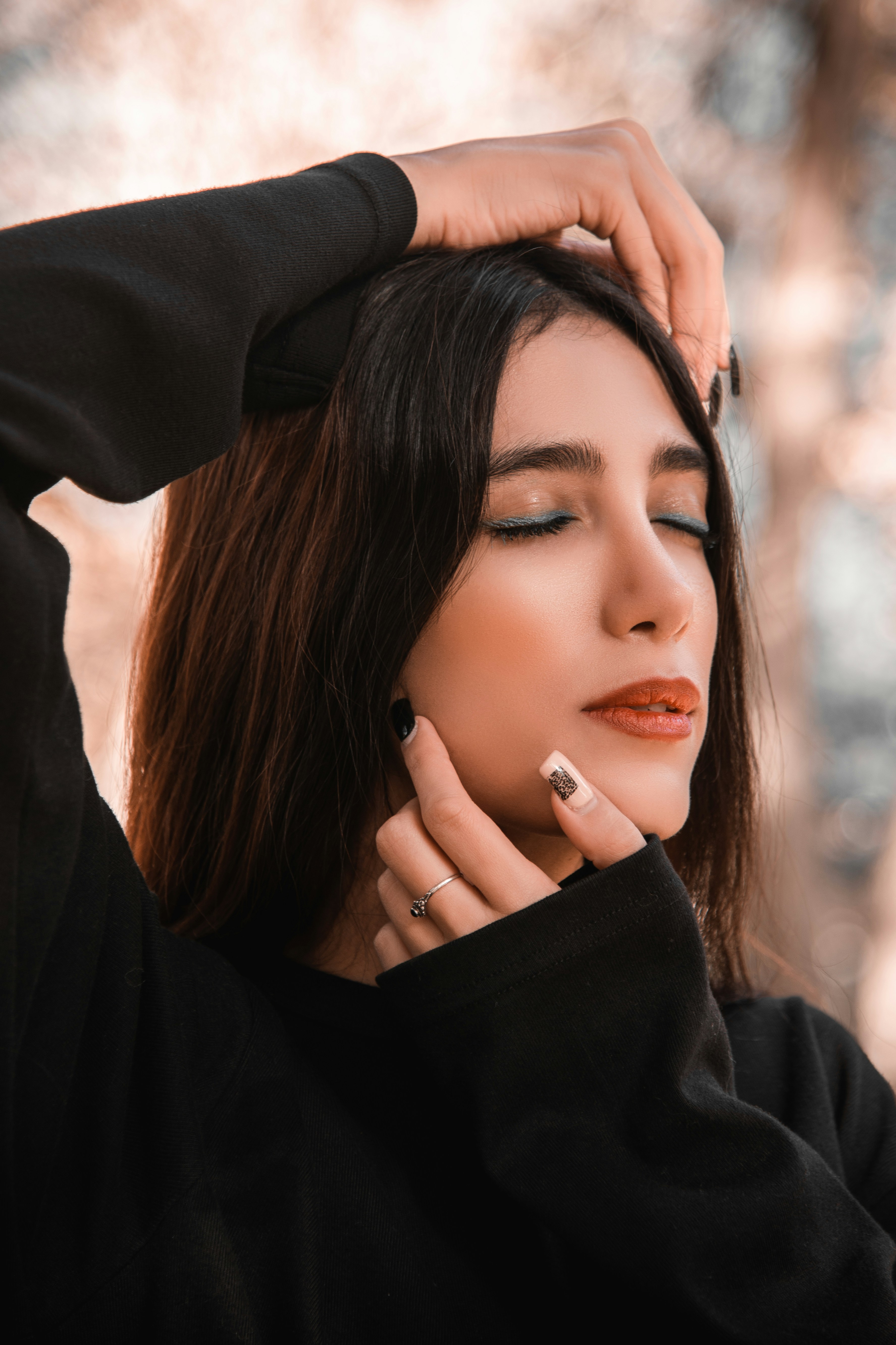 Woman with eyes closed, hands on face