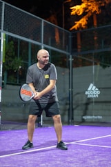 Man playing padel tennis at night