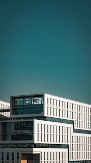 Modern white building with geometric design against blue sky