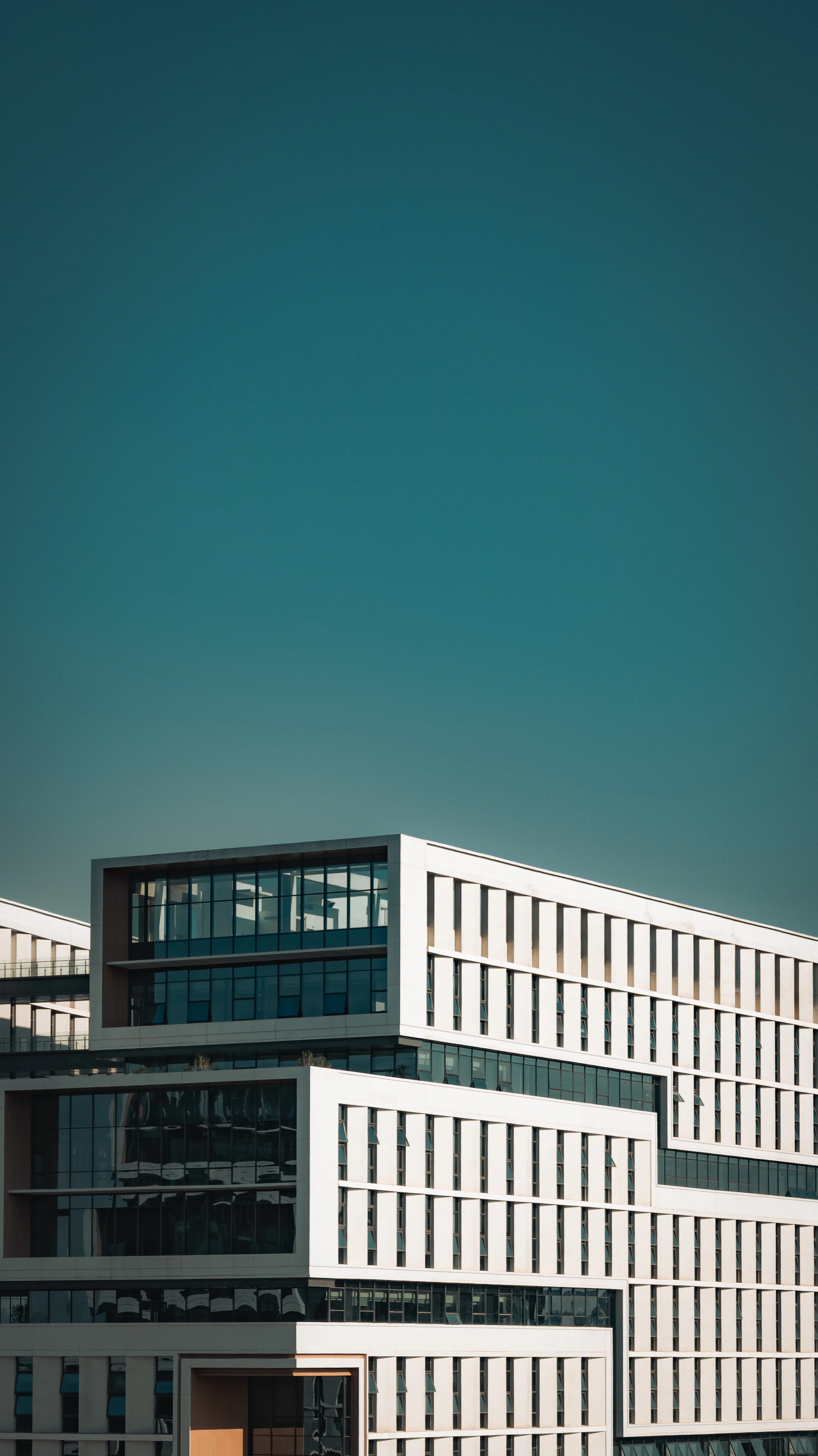 Modern white building with geometric design against blue sky