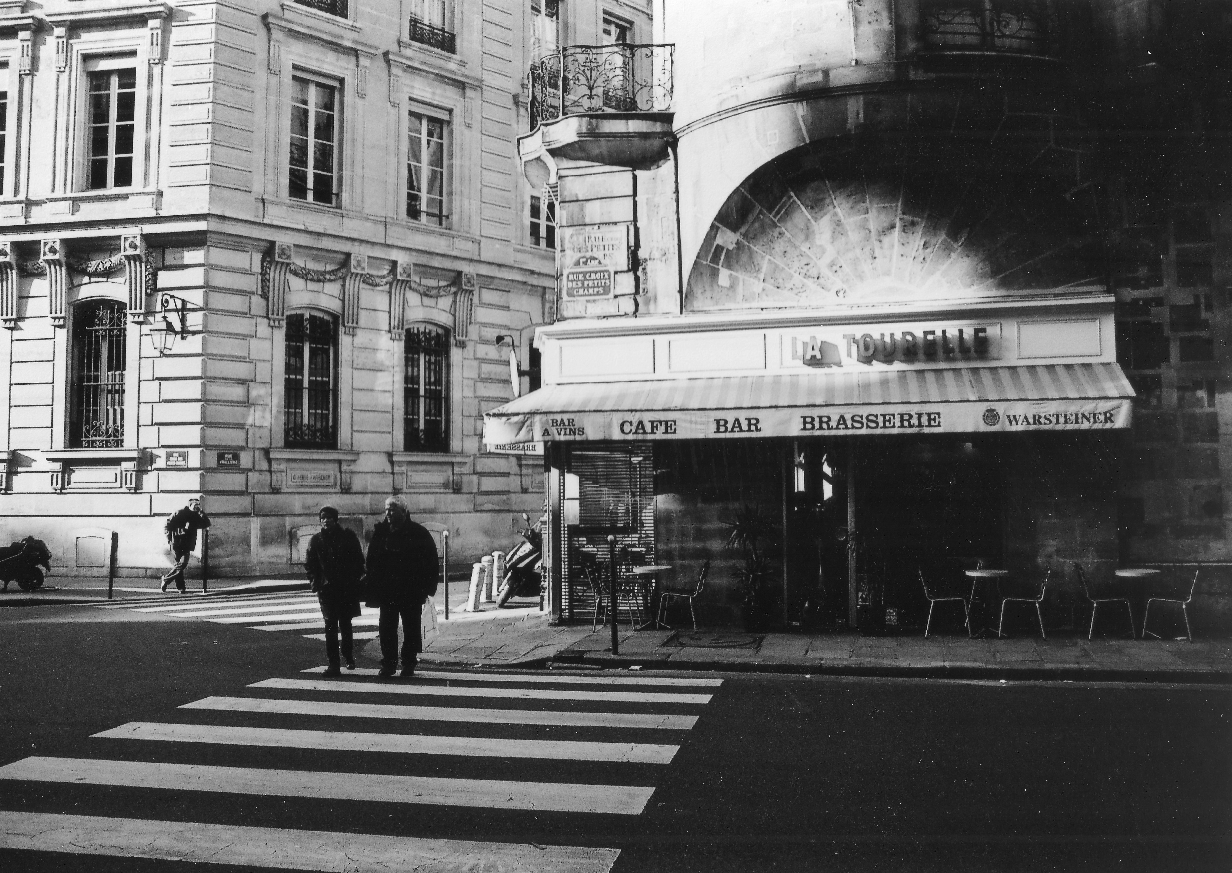 Two people walk across a crosswalk near a cafe. photo – Free Travel ...