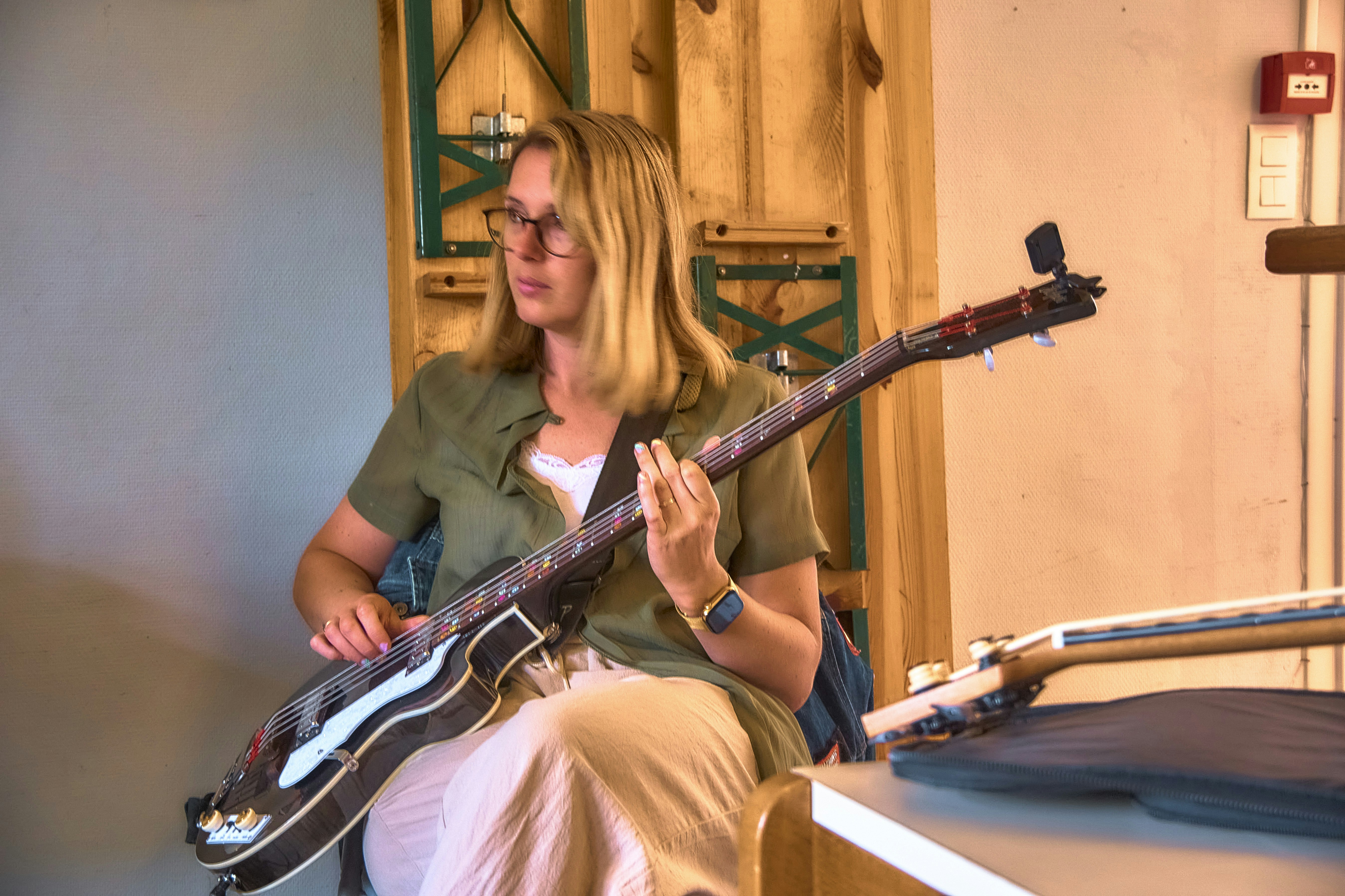Woman playing a bass guitar indoors