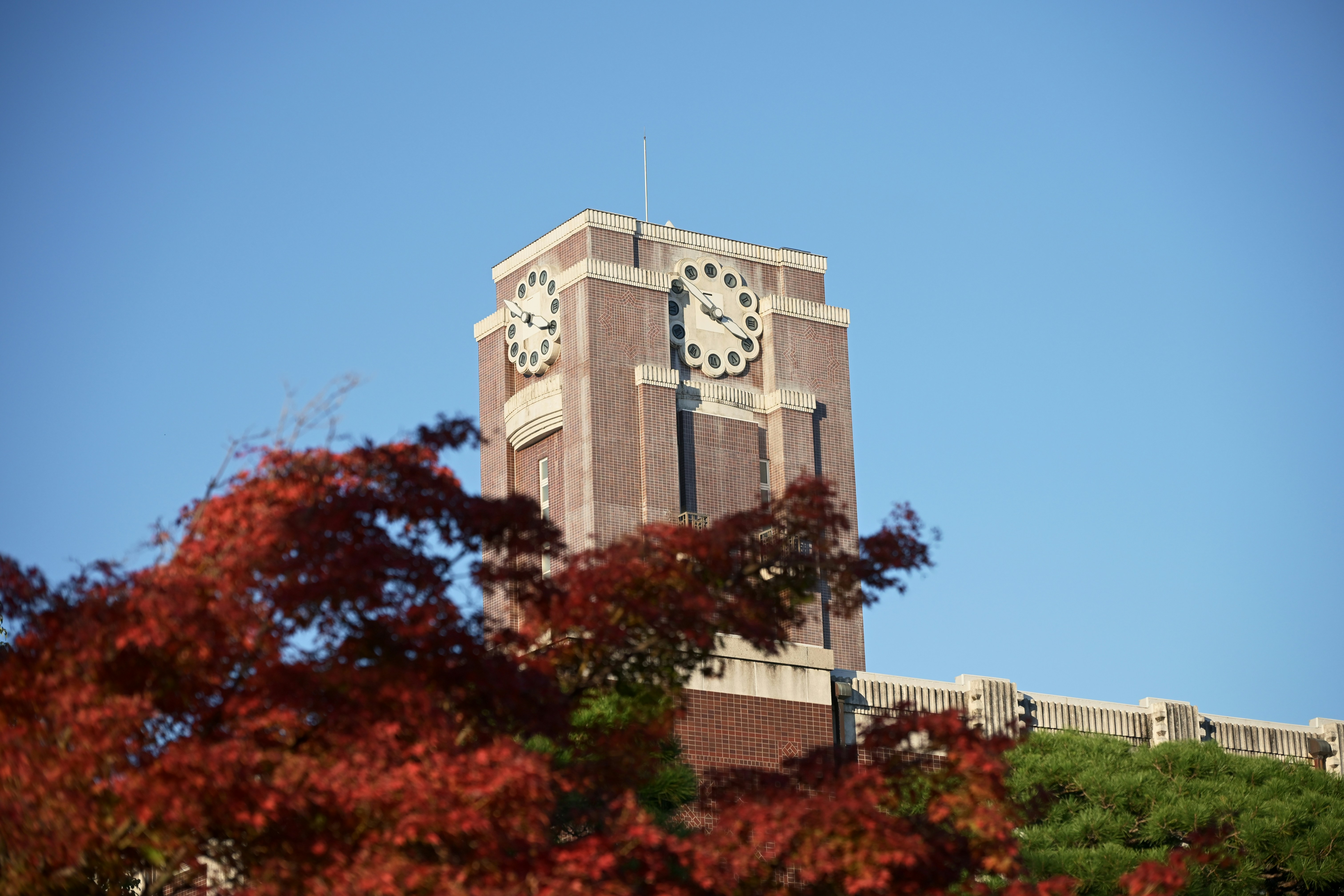Brick clock tower against a clear blue sky.