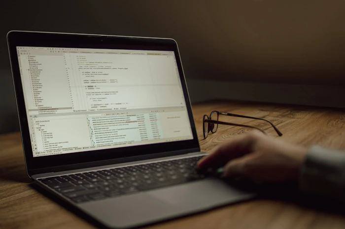 Developer typing on a laptop with an AI chat-based coding assistant