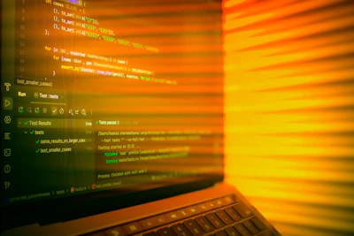 Laptop screen displaying code with orange glow.