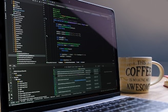 Laptop screen displaying code with a coffee mug.