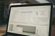 Laptop screen displaying code and data charts.